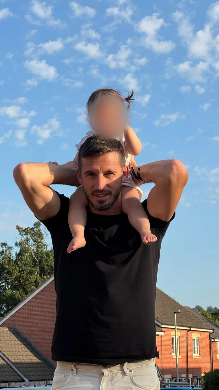 Lewis with his daughter on his shoulders on a summer evening
